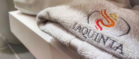 A stack of towels with embroidered logos on a white surface.