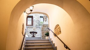 A staircase leading to a stone building with a small table and chairs at the top. - Palazzo Iaquinta - Rooms & Restaurant (Cicerale)