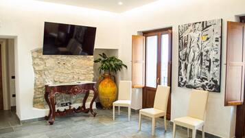 A modern interior with a stone wall, a large vase, and two chairs.