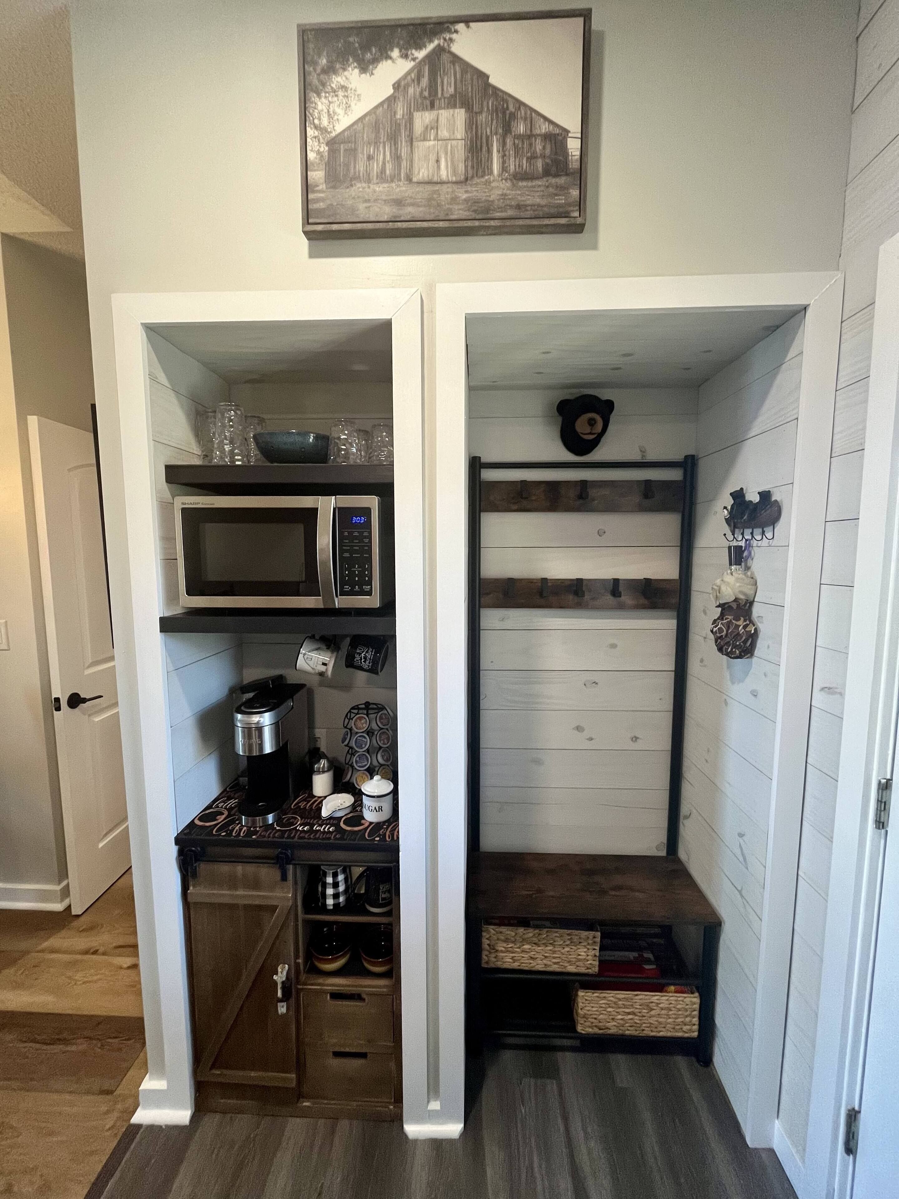 A compact kitchen with a microwave, coffee maker, and storage shelves.
