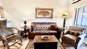 A living room with a brown sofa, a wooden coffee table, and a patterned rug.
