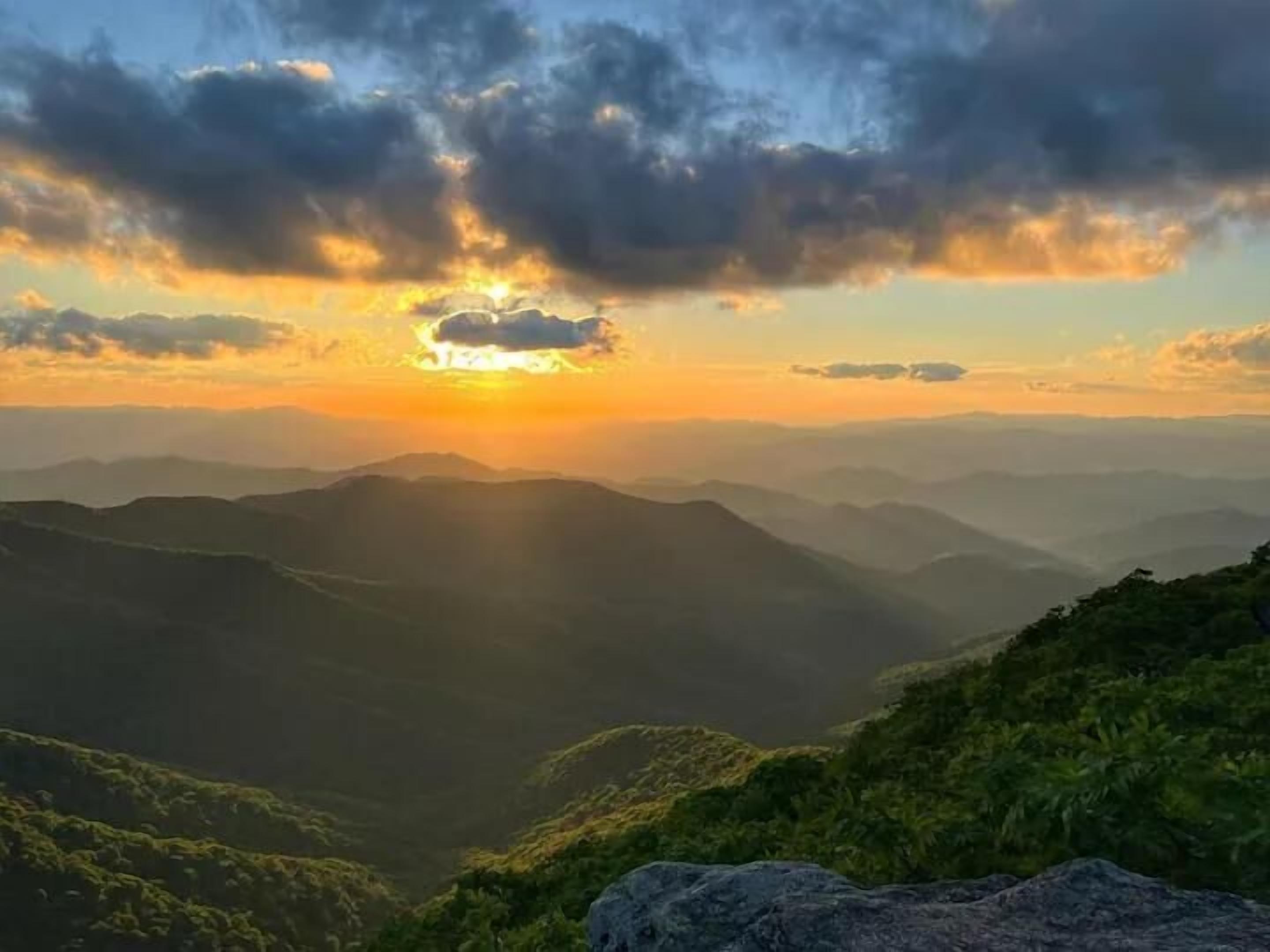 A mountainous landscape with a sunset.