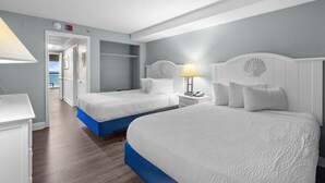 A hotel room with two beds, a desk, and a view of the sea. - Majestic Oceanfront Ste with Hot Breakfast 3rd Flr (Myrtle Beach)