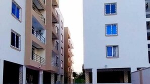 Une piscine entourée d’immeubles à plusieurs étages, dotés de balcons et de fenêtres.