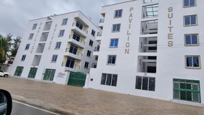 Un hôtel à plusieurs étages, doté d’une façade en briques et de balcons, et dont l’enseigne indique la présence de « suites de type pavillon ».