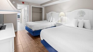 A hotel room with two beds, a desk, and a bedside table with a lamp. - Airy Oceanfront Suite: Includes Hot Breakfast (Myrtle Beach)