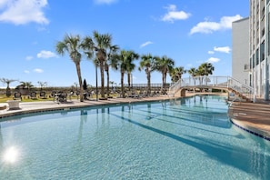 A clear swimming pool with lounge chairs and palm trees. - Airy Oceanfront Suite 4th Flr with Breakfast (Myrtle Beach)