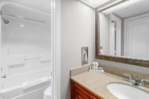 Bathroom features a bathtub, toilet, and vanity with a granite countertop.