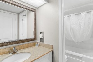 A bathroom with a sink, mirror, and shower curtain. - Spacious Oceanfront Suite: 5th Flr W Breakfast (Myrtle Beach)