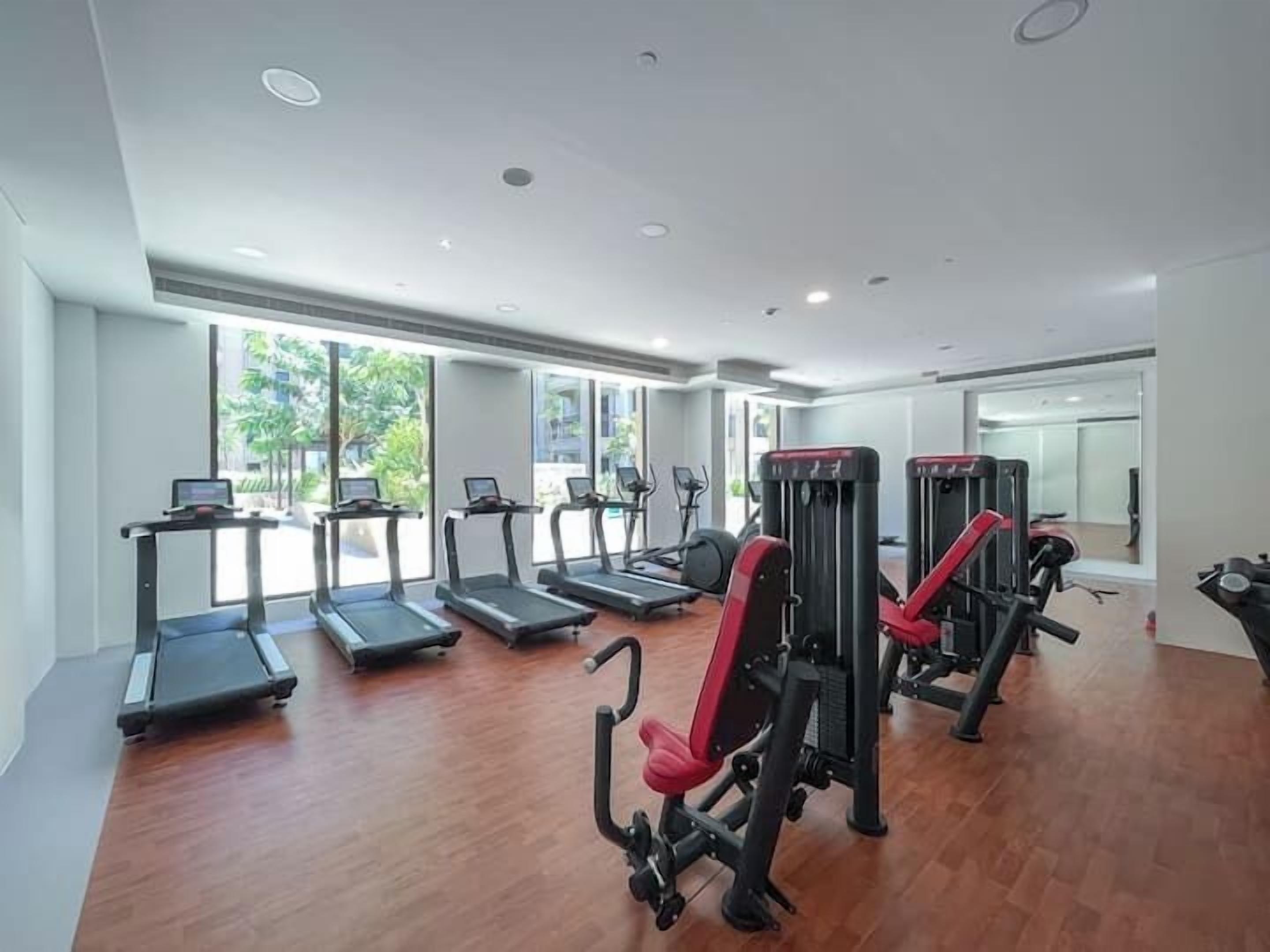 A gym with treadmills, elliptical machines, and weight equipment.