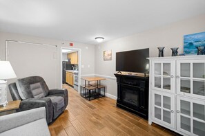 Una sala de estar con chimenea, televisor y mueble de almacenamiento.