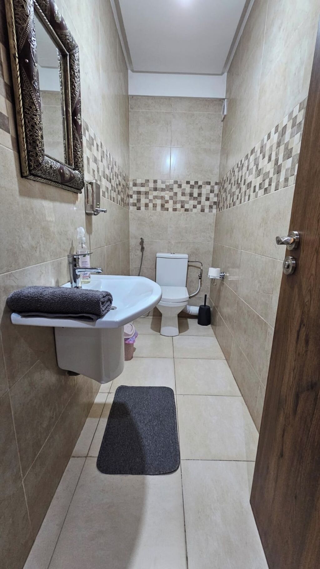 A bathroom with a white sink, a toilet, and a mirror.
