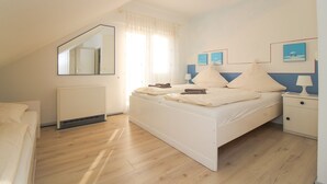 Una camera da letto con un letto, un comodino, uno specchio e una finestra con tende.