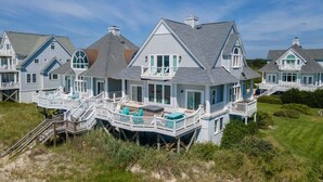 Une maison située sur la côte, dotée d  ’une grande terrasse et de plusieurs niveaux.