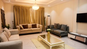 A modern living room with two sofas, a coffee table, and a TV.
