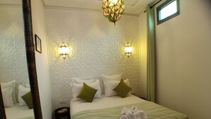 A hotel room with two beds, green bedding, a wall with a geometric pattern, and two wall-mounted lights. - Riad Beni Sidel (Marrakech)