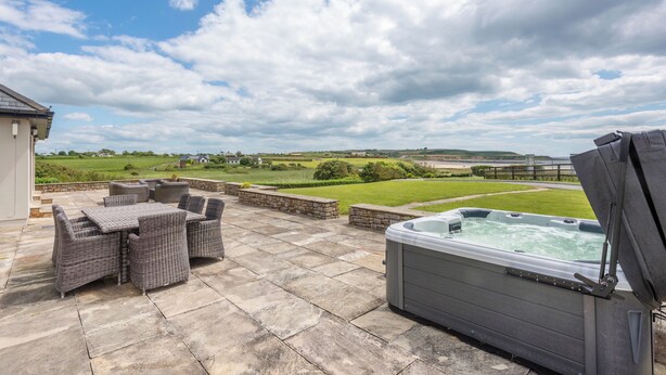 An outdoor patio with wicker furniture and a hot tub. - 5 Bed Villa - Sleeps 10 - Hot Tub - Country Views (Ardmore)