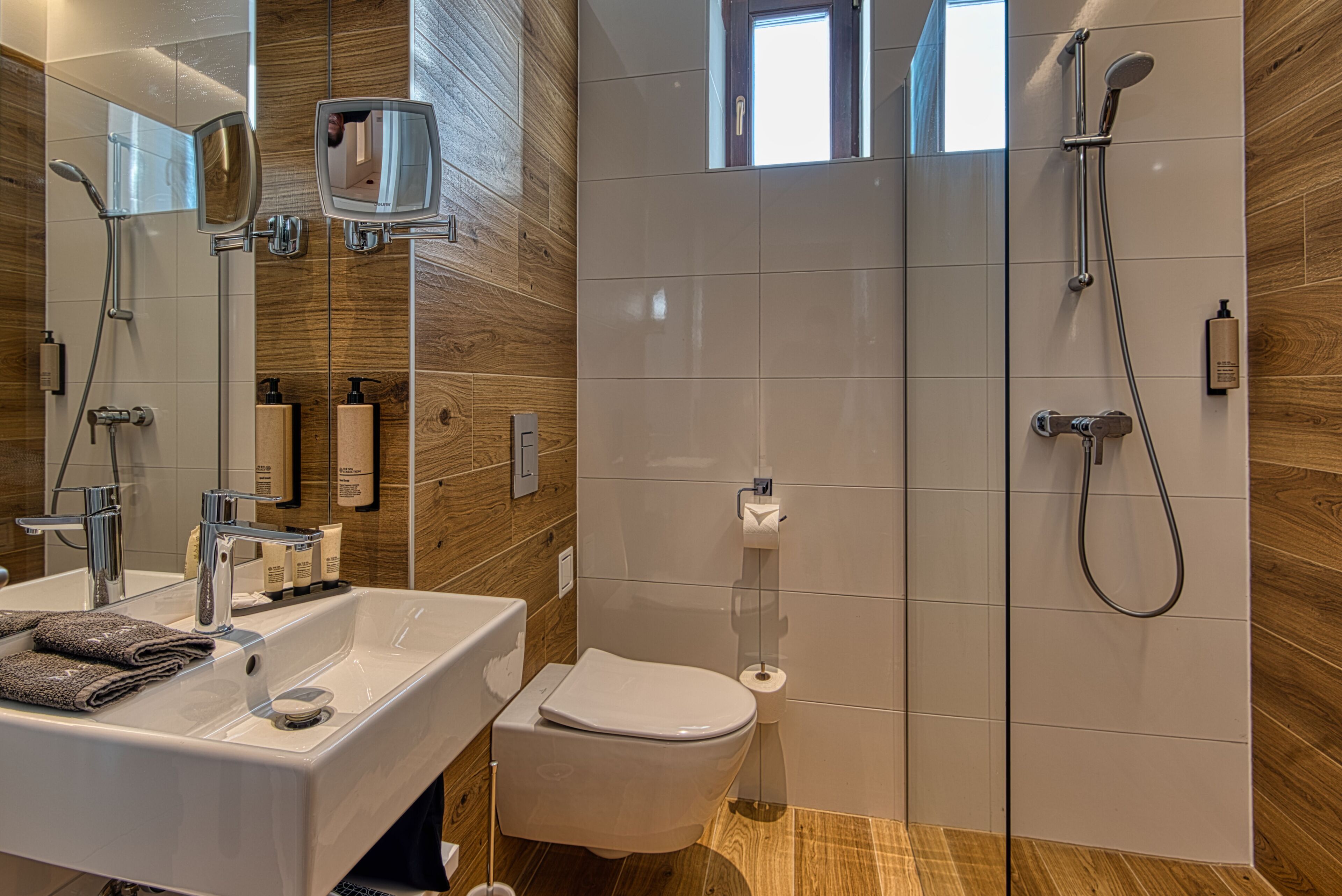 A modern bathroom with a large sink, mirror, toilet, and shower.