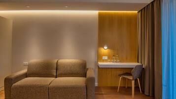 Una habitación moderna con un sofá, una mesita con una silla y una pared con listones de madera verticales.
