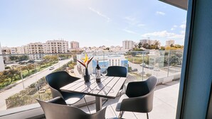 A balcony with a table and chairs, a bottle of wine, and a glass of water. - Terrace Daniel (Portimao)