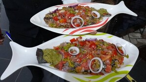 Two white fish-shaped plates with a colorful salad and slices of onion. - African Hill Hotel & Resort (Ho)