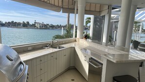 Cucina con vista sull'acqua, dotata di griglia e cestino.