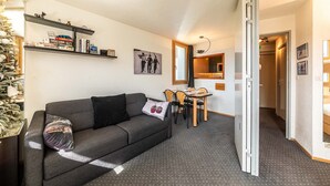 Een knus woongedeelte met een bank, een eettafel en een kitchenette.