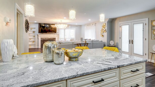 A modern kitchen with a marble countertop, hanging pendant lights, and a central island with decorative vases. - Silver Springs Home: Walk to Downtown! (Silver Spring)