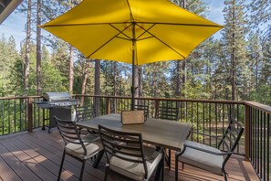 Enjoy a meal or a moment of relaxation on the patio, surrounded by tall trees.