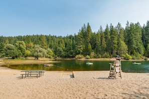 A beach with a picnic table and a lifeguard stand. - Bronco Bear's Hideaway- Golf, BLS, EV charger (Arnold)