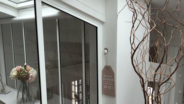 A modern interior with a large window, a vase with flowers, and a tag on the wall.