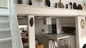 A modern kitchen with white cabinetry, a central island, and a dining area.