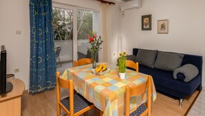 A room with a dining table, chairs, a sofa, and a TV. - 2 bedroom lovely apartment in Baska (Baska)