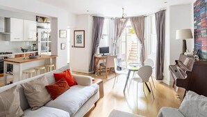Een moderne woonkamer met een bank, een eettafel en een piano.