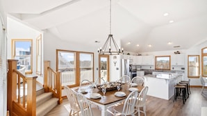 Una cocina amplia con una isla central, muebles blancos y vistas a la ciudad.