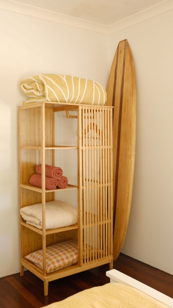 A wooden shelf unit with towels and a surfboard. - The Sunshine Shack - enjoy the beach and relax in our sunny holiday heaven (Falcon)