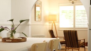 Un espace repas comprenant une table, des chaises et une lampe.