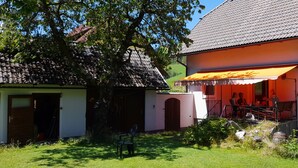Una casa tradicional con techo de tejas, un porche de madera y una antena parabólica.