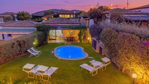 A residential property with a swimming pool, outdoor seating, and a well-maintained garden. - Casa Maestrale 6, Emma Villas (Palau)
