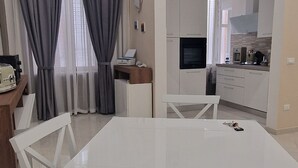 A modern kitchen with white cabinets, a microwave, and a stove.
