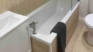 A modern bathroom with a glass-enclosed shower, a white bathtub, and a toilet. - The Victorian Apartment (Dundee)