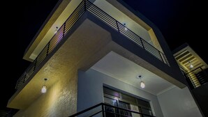 Een meerhoog gebouw met balkons, leuningen en hangende lichten.