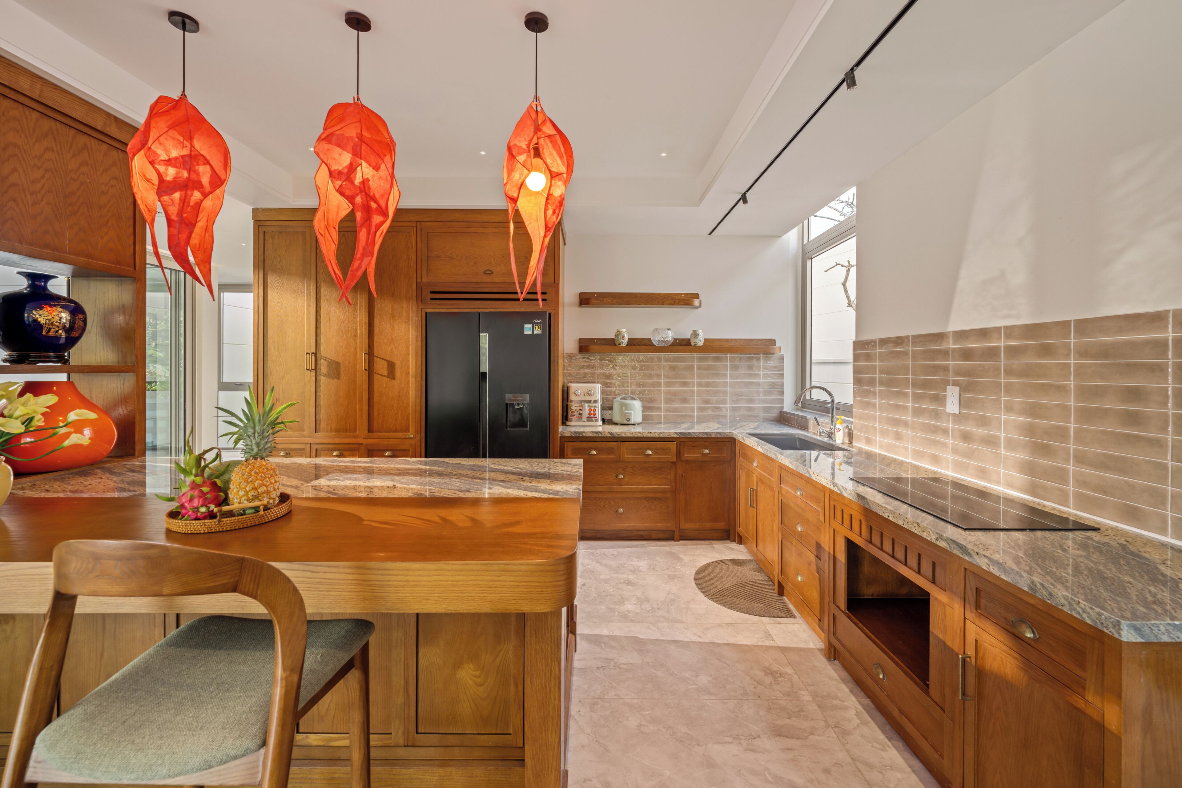 A modern kitchen with wooden cabinets, a marble countertop, and a central island.
