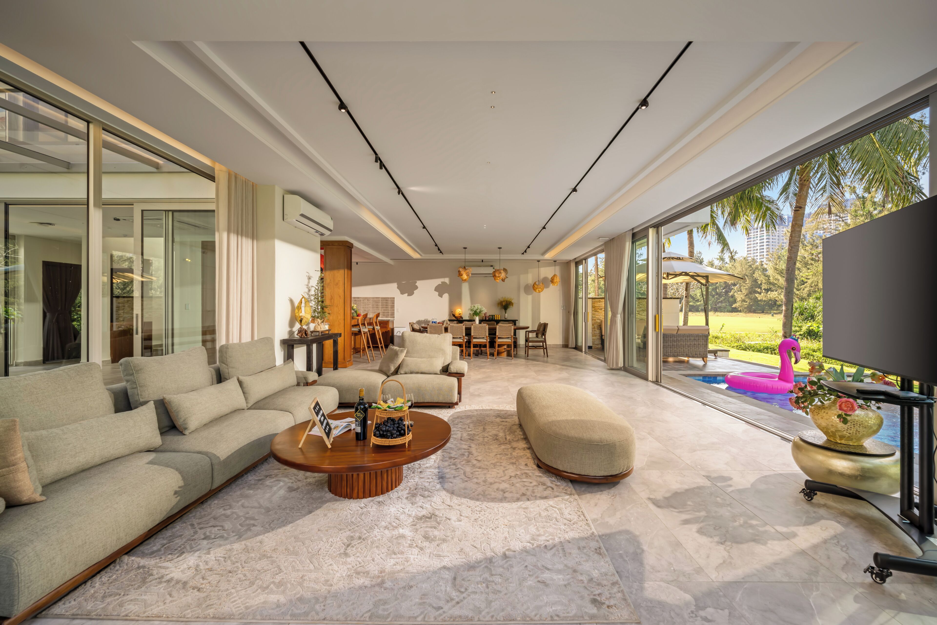 A spacious living room with a large sofa, a coffee table, and a television.