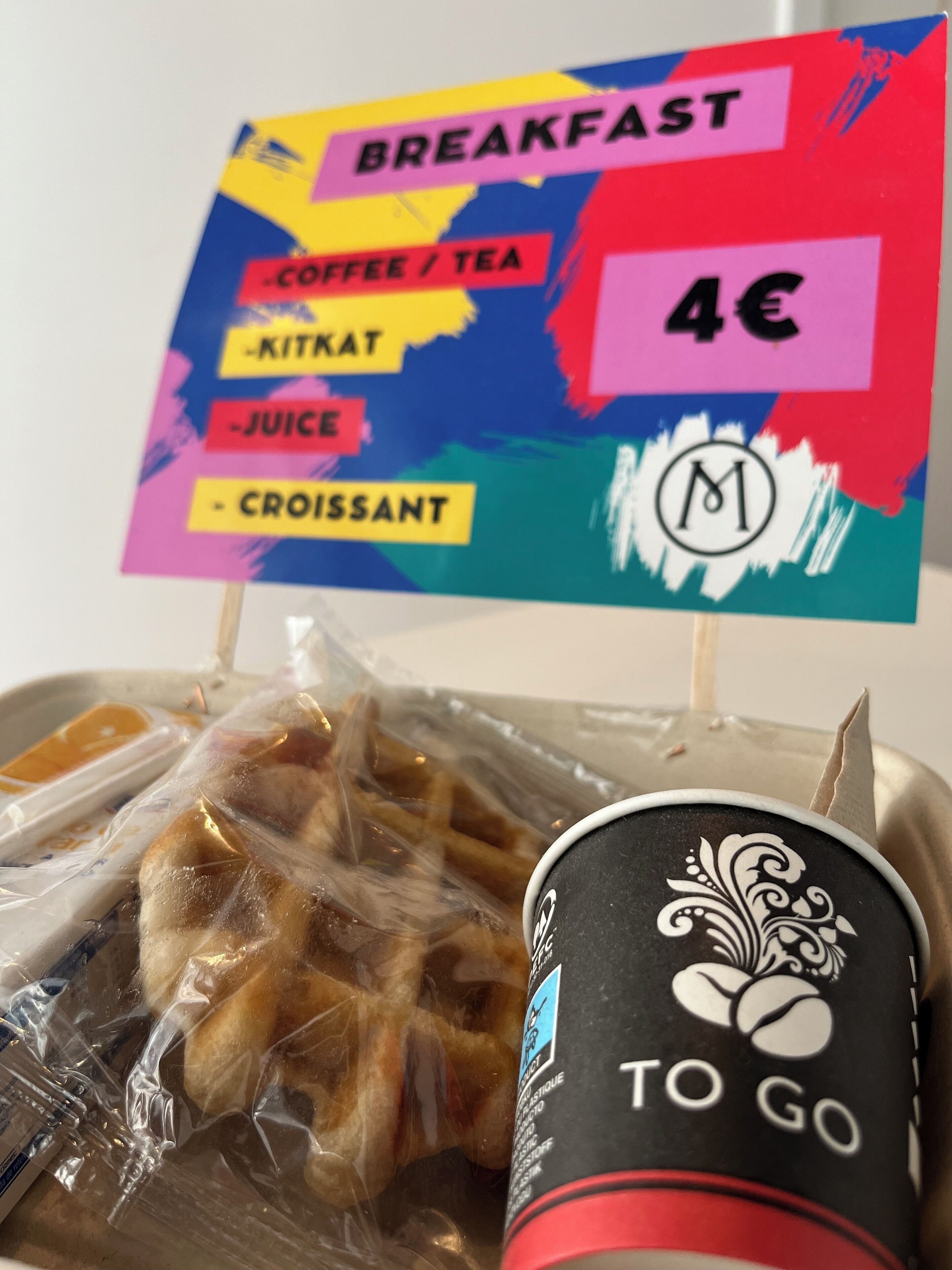 Un menú de desayuno que incluye café, té, jugo y croissant, con un precio de 4€.