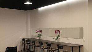 A conference room with a long table and six chairs. There are potted orchids on the table. - MPods Málaga (Málaga)