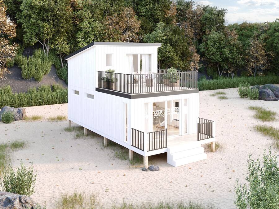 Ein zweistöckiges Strandhaus mit Balkon, gelegen an einem Sandstrand mit Bäumen im Hintergrund.