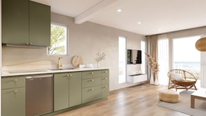 A modern kitchen with green cabinets, a stainless steel dishwasher, and a large window. - Hideaway Bay Resort (Silver Creek)
