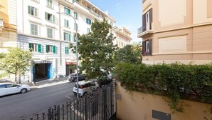Une vue de rue avec un bâtiment portant l’inscription « GRAND GARAGE » et un arbre au premier plan.