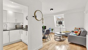A modern apartment with a kitchen, dining area, and living room. - Contemporary Oasis in Paddington III (London)